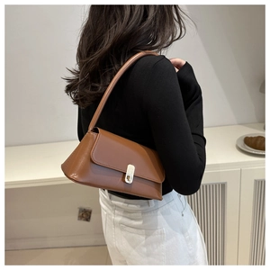 Gros plan du sac porté épaule vintage marron avec fermoir rotatif doré élégant