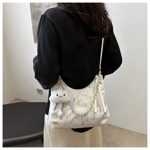Détail du sac sous l'épaule matelassé blanc avec rayures colorées et breloque nuage