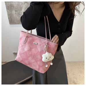 Detailed view of pink quilted tote bag with cute cloud charm and smooth leather strap
