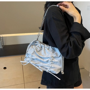 Detailed close-up of light blue pleated tote bag with silver chain and bead accents