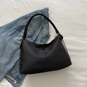 Black nylon tote bag with triangle metal logo and silver chain on a white background