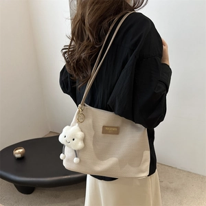 Minimalist beige corduroy tote bag with leather logo patch and plush cloud charm