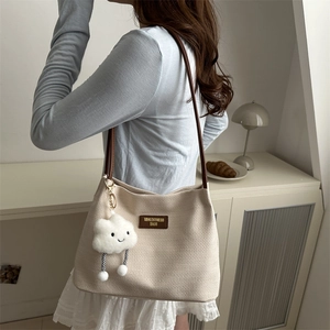Chic beige waffle texture tote bag with brown leather straps and cloud pendant