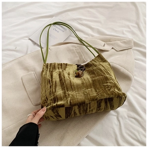 Detail of green bamboo pattern tote bag with velvet texture and luxury leather handles