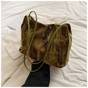 Detail of dark green velvet tote with bamboo leaf patterns and wooden bead drawstring