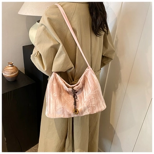 Detail of pink velvet tote with embossed botanical texture and drawstring wooden pendant