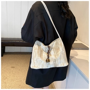 Detailed shot of pleated texture and amber pendant on this beige Chinese style tote bag