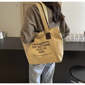 Détail du grand sac cabas en toile avec typographie de mode et accents en cuir