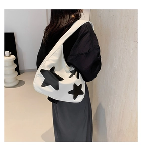 Detail of white nylon tote bag with black star prints and wide shoulder strap