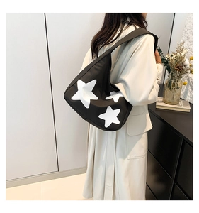 Detail of hobo shoulder bag featuring a contrast white star pattern on black nylon fabric