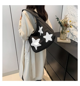 Detailed side view of large black tote bag featuring distinctive white star prints