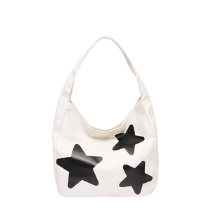 White minimalist tote bag with black star prints and wide shoulder strap in studio shot