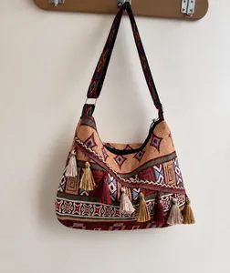 Λεπτομέρεια boho υφαντής τσάντας με χρωματιστά γεωμετρικά σχέδια και φούντες