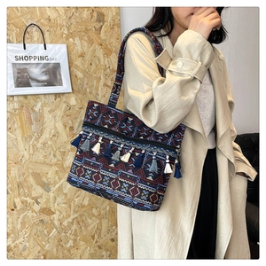 Close-up of ethnic woven tote bag with colorful geometric patterns and decorative tassels