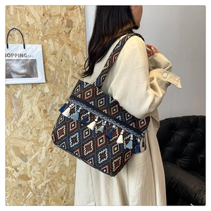 Close-up of ethnic tote bag with colorful geometric patterns and fringe tassel details