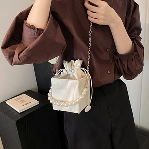 Chic white embossed bucket bag with pearl handle and gold chain strap for women