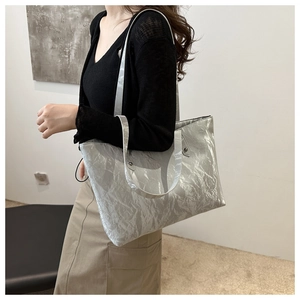 Sac cabas argenté texturé porté par un mannequin pour un look de bureau chic moderne