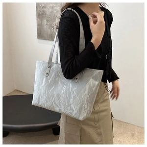 Detail of silver grey tote bag with cloud texture and rivet reinforced shoulder straps