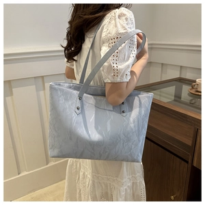 Close-up of light blue large tote bag with wrinkled texture and stylish long shoulder straps