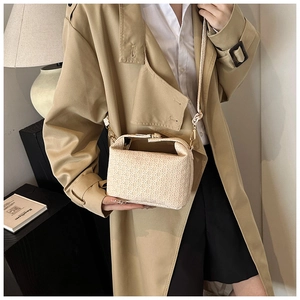 Detail of cream woven handbag showing geometric triangle texture and metal clasp