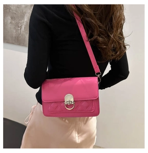 Detailed side view of rose red crossbody bag with rhombic stitching and silver buckle