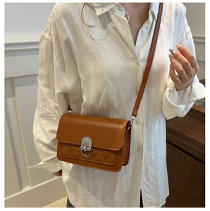 Brown vintage crossbody bag with diamond quilting and silver lock shown on a model