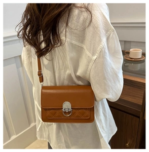 Détail d'un sac à bandoulière en cuir matelassé marron avec fermoir en métal argenté