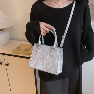Minimalist silver metallic crossbody bag with textured faux leather and top handle