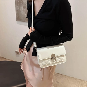 White quilted PU leather crossbody bag with silver twist lock shown on model