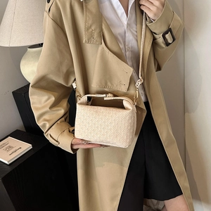 Elegant beige woven crossbody bag with doctor bag closure shown on a female model