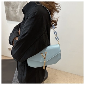Light blue shoulder bag for women, stylish crossbody bag with metal V logo and chain strap.