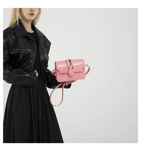 Pink glossy square crossbody bag featuring golden hardware and a matching leather strap