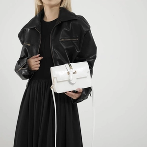 Minimalist white square crossbody bag with gold hardware and black zip detail