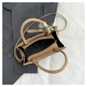 Internal view of light brown tote bag showing black lining, metal zipper, and silk scarf wrap