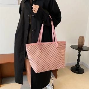 Pink large capacity monogram tote bag with top handles shown on model in black coat