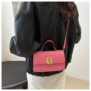 Detail of pink faux leather crossbody bag with vintage golden G buckle and top handle