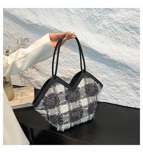 Détail du sac cabas en laine à carreaux gris avec bords effilochés et coupe en V