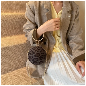 Detail of leopard print ball purse with gold metal ring handle and chain strap