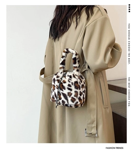 Detail of leopard print plush bucket bag with metal chain strap on khaki trench coat