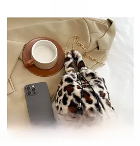 Detail shot of leopard print faux fur bucket bag with golden chain and drawstring