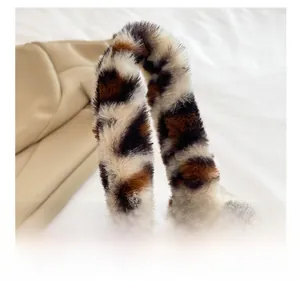 Close-up of plush leopard print bucket bag featuring round handle and soft faux fur texture