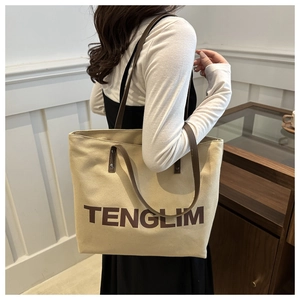 Detail of large canvas tote bag with leather straps on a model for casual daily commute