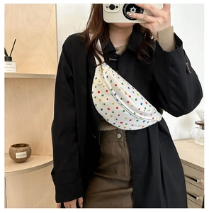Detail shot of white floral canvas chest bag with colorful dots and adjustable strap