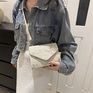 Sac bandoulière en paille tressée avec broderie florale et bandoulière blanche sur modèle