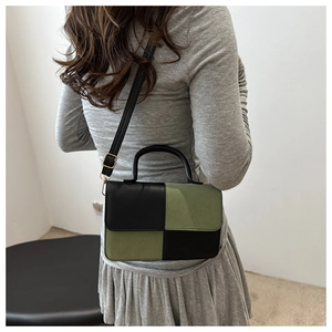 Detail of crossbody bag with black and moss green checkered pattern and gold hardware