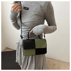 Dettaglio della borsa bicolore nero e verde oliva con elegante manico curvo