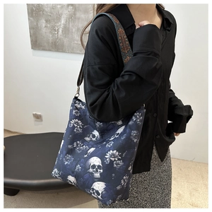 Detail of gothic skull and floral print on navy canvas bag with ethnic woven strap