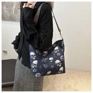 Detail of navy canvas bag featuring white skull floral print and boho jacquard strap