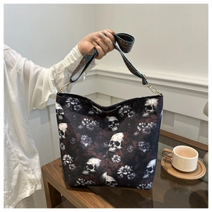 Detail of skull and floral print canvas tote bag with vintage woven crossbody shoulder strap