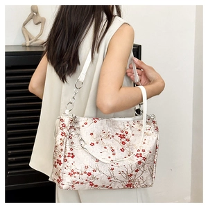 Detail of floral silk shoulder bag with red plum blossom pattern and chain strap